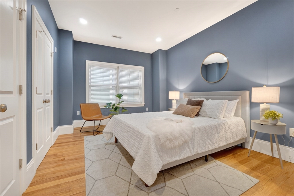 13 Howell Street, Unit 3 Boston, MA 02125 - Photo 13 of 31 a bedroom with a bed and dresser with mirror