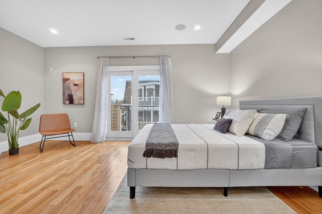 13 Howell Street, Unit 3 Boston, MA 02125 - Photo 16 of 31 a bedroom with a bed chair and wooden floor