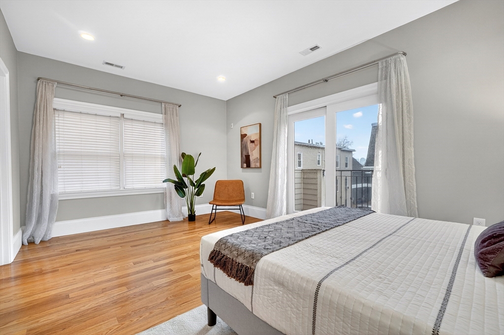 13 Howell Street, Unit 3 Boston, MA 02125 - Photo 17 of 31 a bedroom with a bed and wooden floor