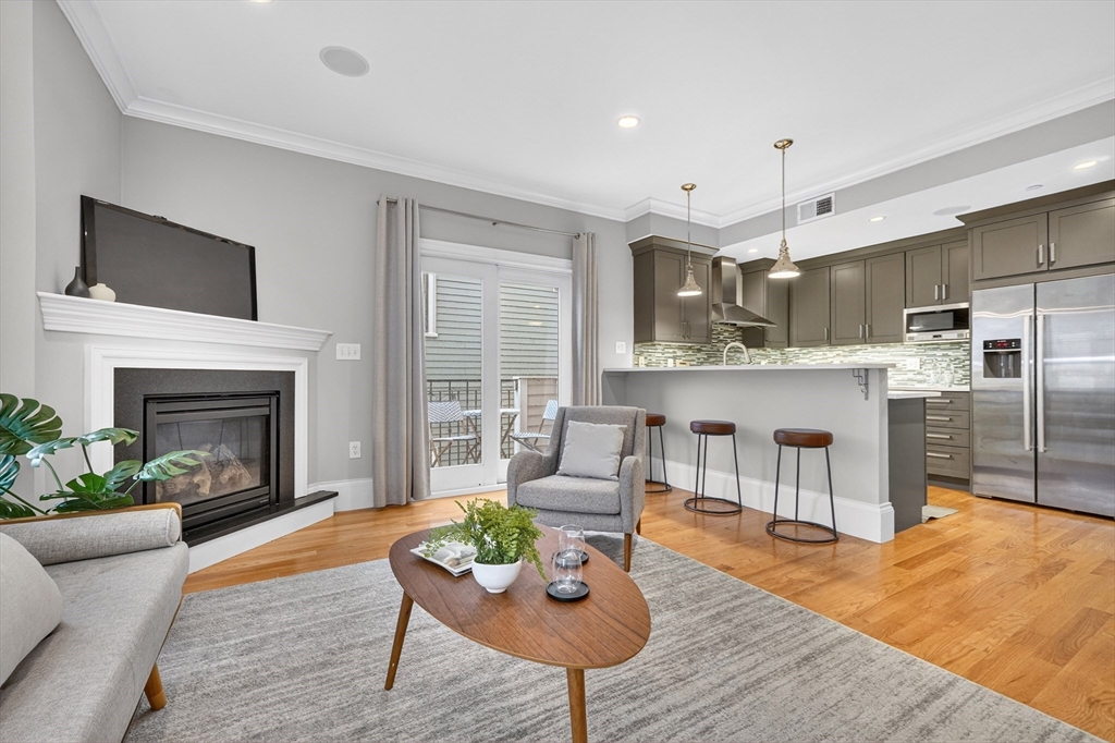 13 Howell Street, Unit 3 Boston, MA 02125 - Photo 5 of 31 a living room with stainless steel appliances furniture a fireplace a rug and a flat screen tv