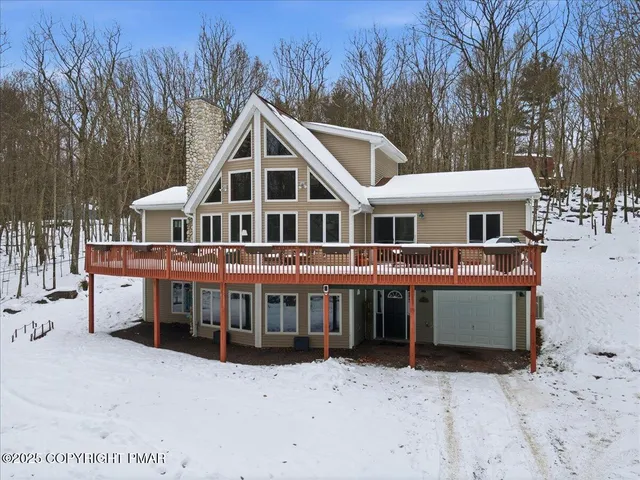 a living room with furniture and large windows with wooden floor