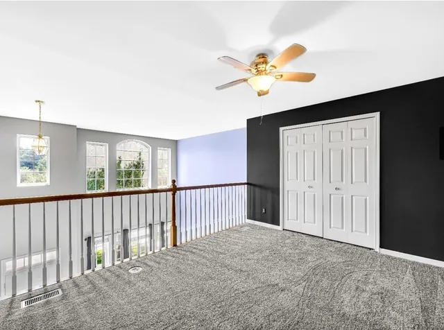 a view of a livingroom with a ceiling fan and window