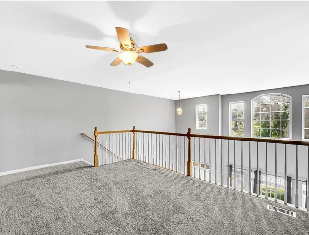 a view of a livingroom with a ceiling fan and window