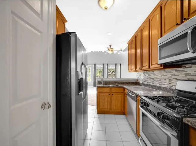 a kitchen with stainless steel appliances granite countertop a stove a sink and a microwave
