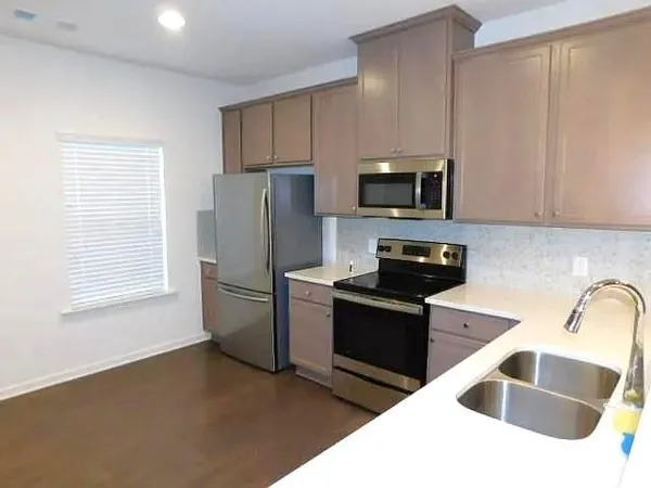 a kitchen with a sink a stove a microwave and refrigerator