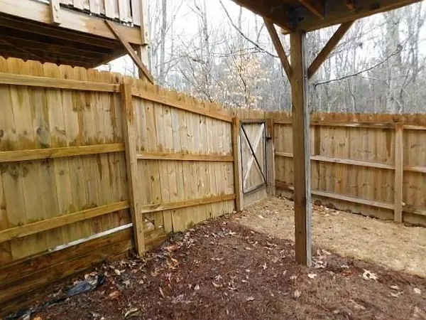 a backyard of a house with wooden fence