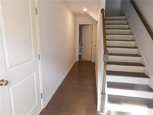 a view of a hallway with wooden floor and entryway