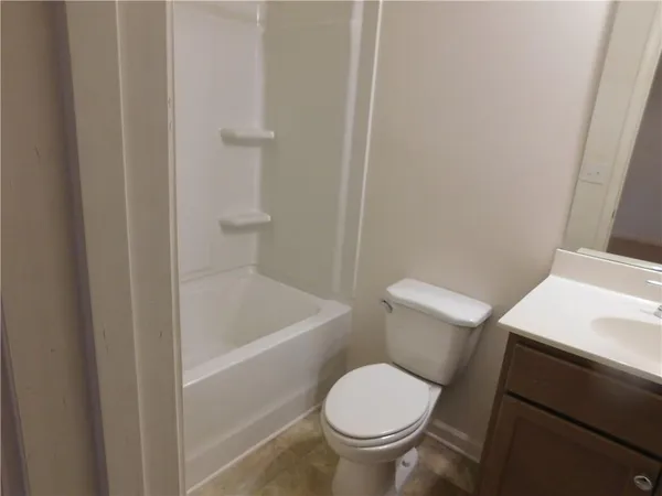 a white toilet sitting next to a bathroom sink and vanity