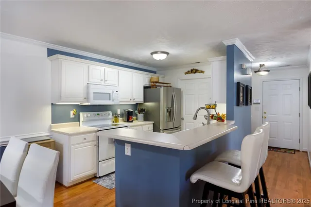 a kitchen with a sink cabinets and wooden floor