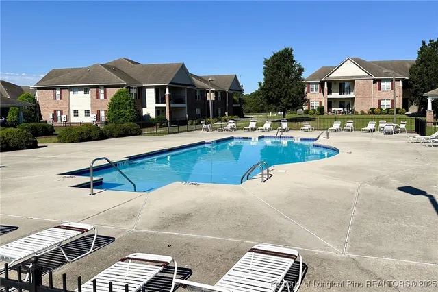 a view of a house with a yard potted plants and a table