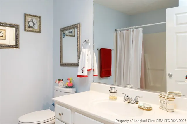 a bathroom with a sink vanity mirror and toilet