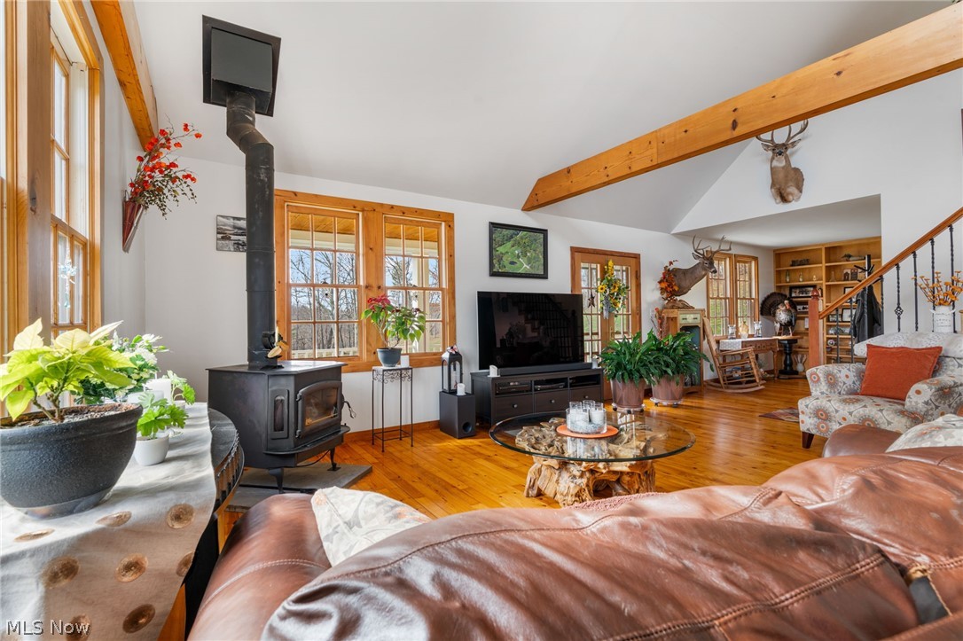 2210 Scroll Road Southwest Carrollton, OH 44615 - Photo 5 of 48 Living room with hardwood / wood-style flooring, a wood stove, plenty of natural light, and vaulted ceiling with beams