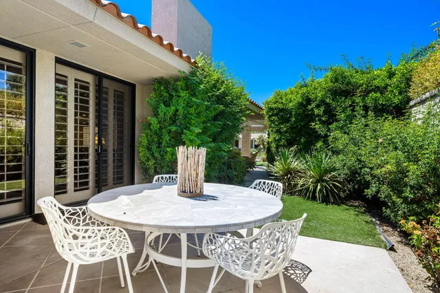a view of a chairs and table in patio with a yard