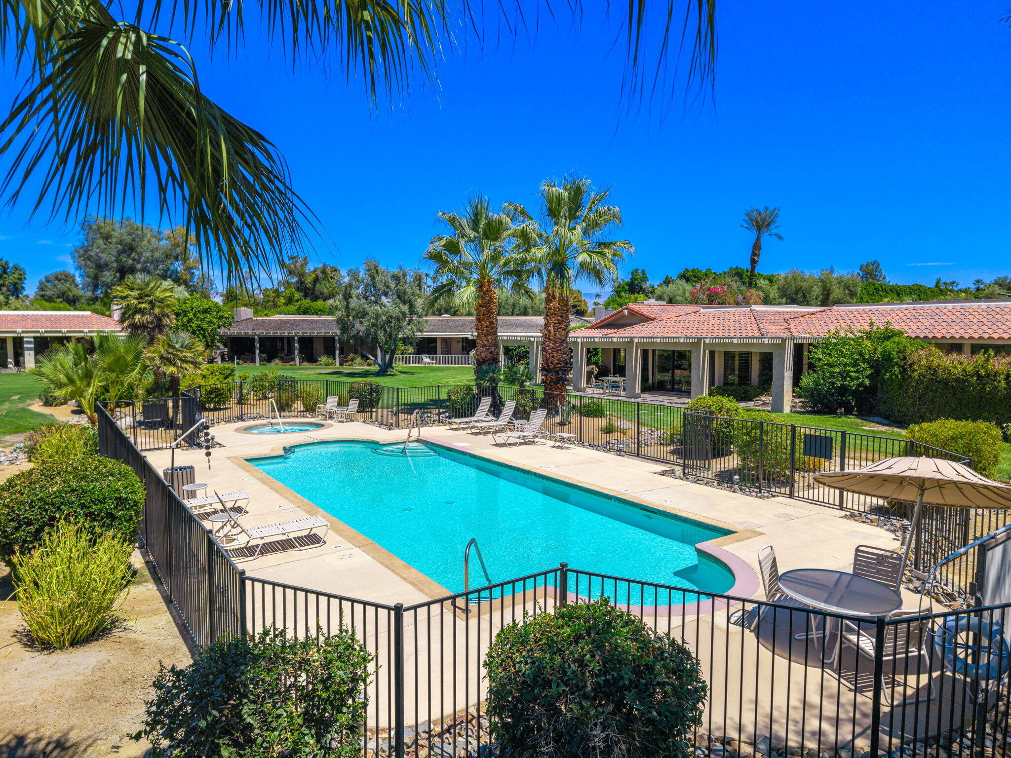 5 Stanford Drive Rancho Mirage, CA 92270 - Photo 42 of 53 a view of a swimming pool with lawn chairs under an umbrella
