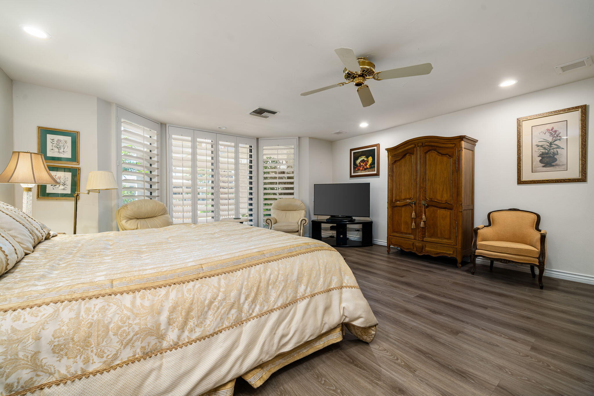 5 Stanford Drive Rancho Mirage, CA 92270 - Photo 44 of 53 a spacious bedroom with a bed a couch and a chandelier
