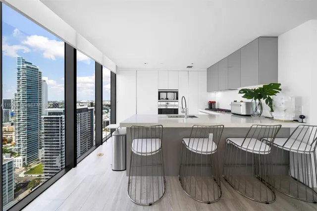 a kitchen with a table chairs and white appliances