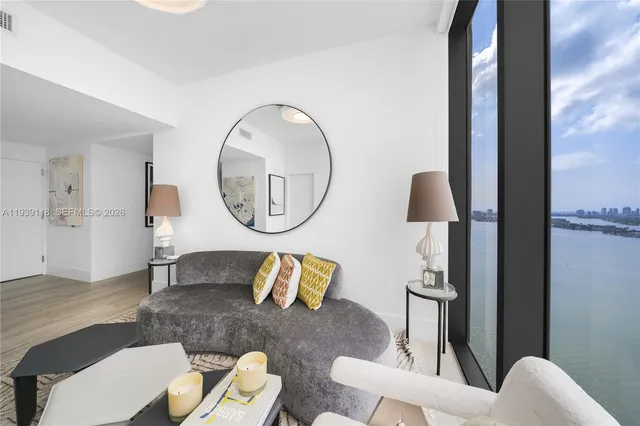 a living room with furniture a mirror and a lamp