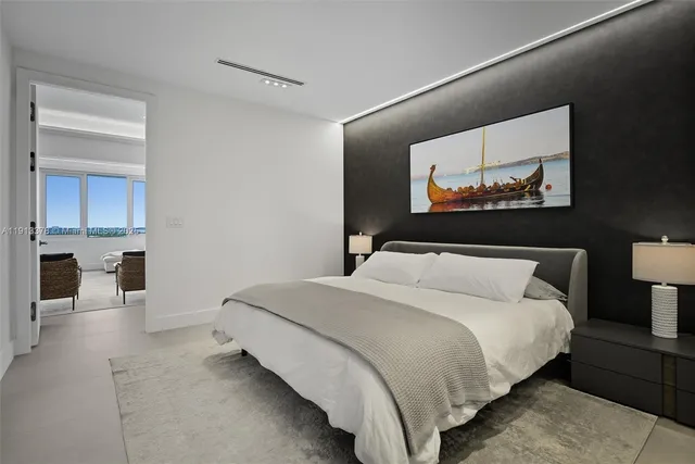 a bedroom with a bed and a painting on the wall