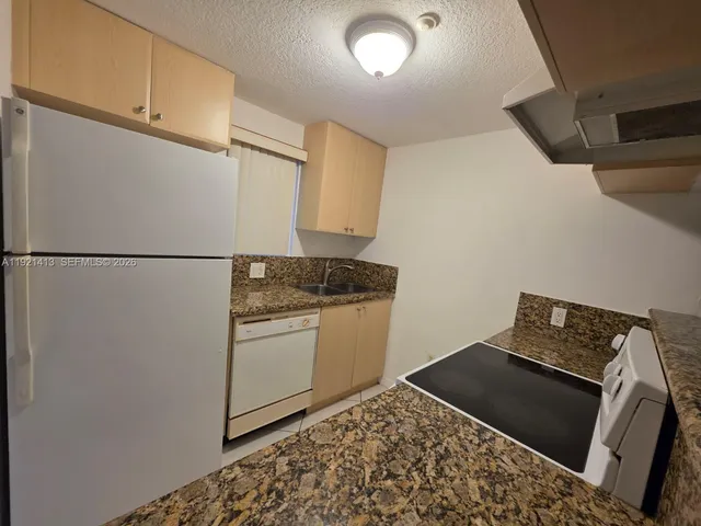 a kitchen with a refrigerator and a stove