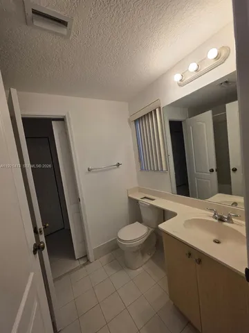 a bathroom with a sink a toilet a mirror and vanity