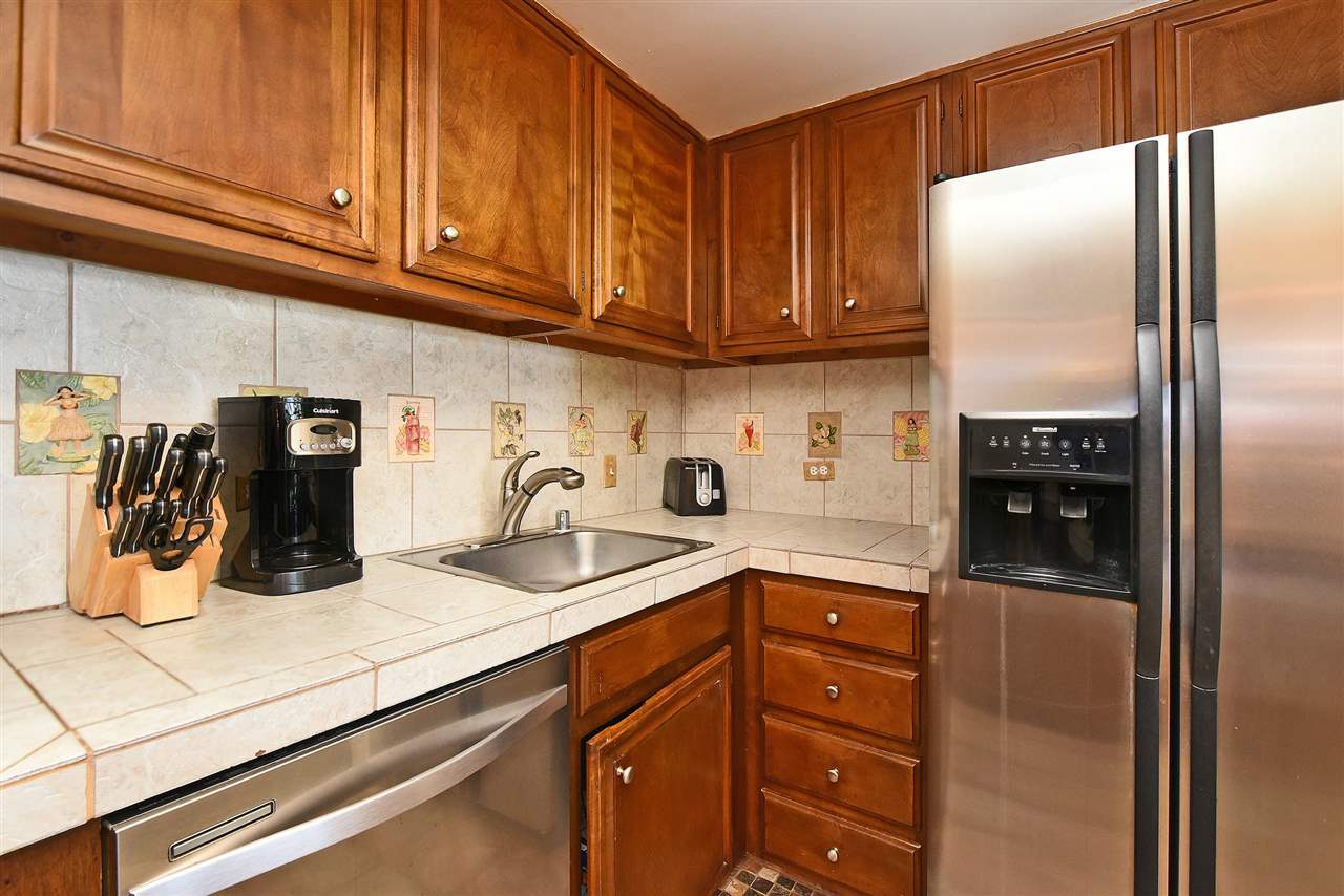 3875 Lower Honoapiilani Road, Unit B103 Lahaina, HI 96761 - Photo 19 of 30 a kitchen with granite countertop stainless steel appliances and refrigerator