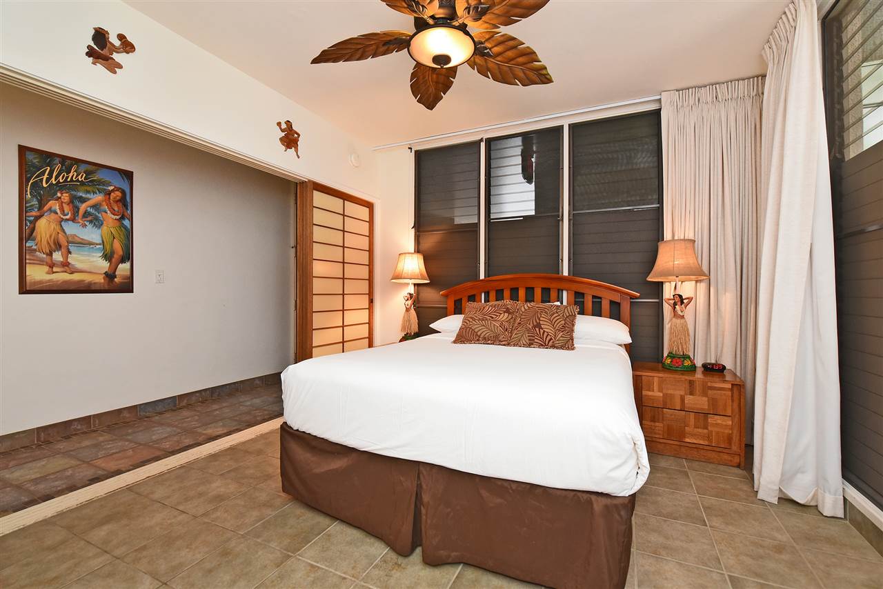 3875 Lower Honoapiilani Road, Unit B103 Lahaina, HI 96761 - Photo 22 of 30 a bedroom with a large bed and a chandelier