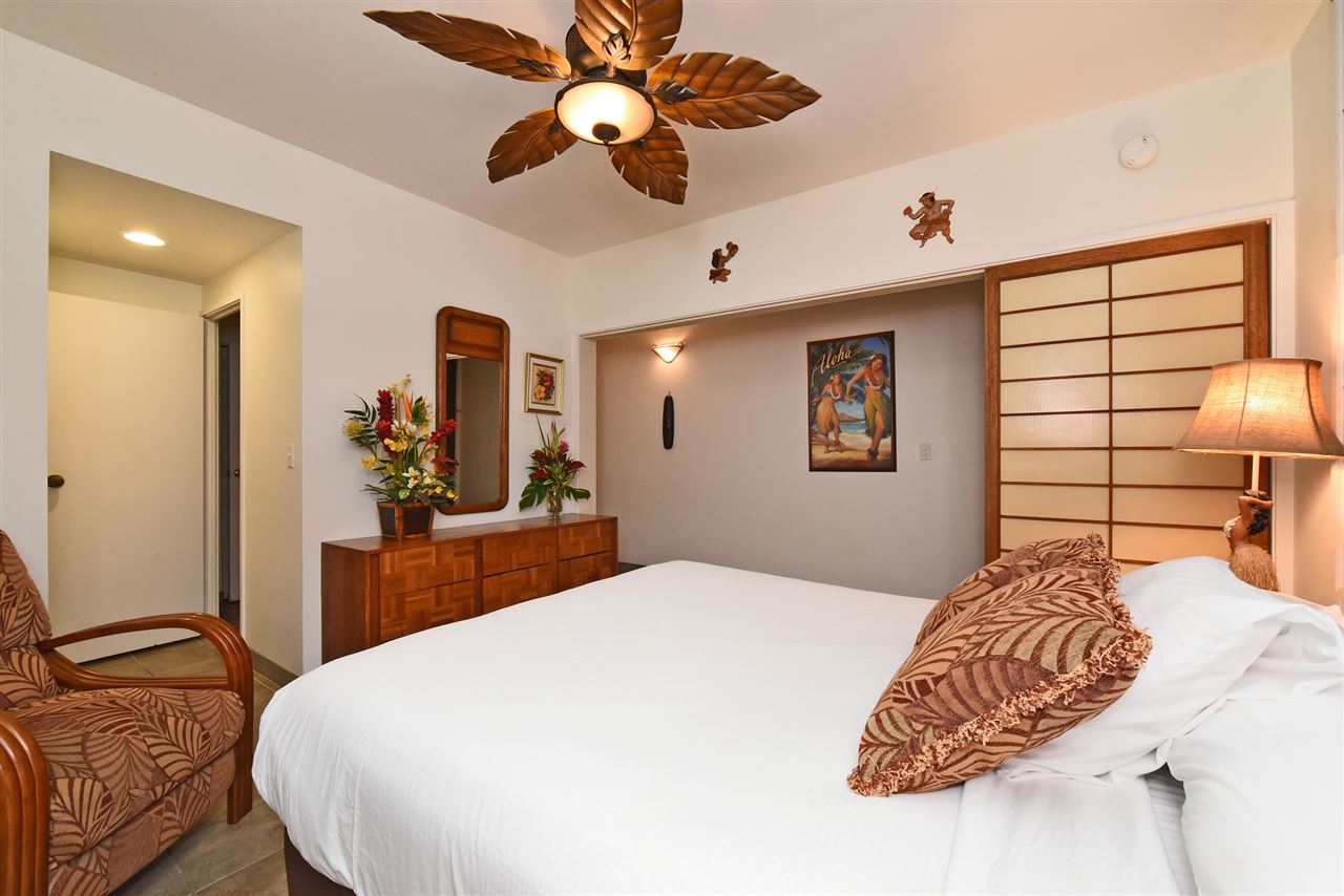 3875 Lower Honoapiilani Road, Unit B103 Lahaina, HI 96761 - Photo 23 of 30 a bedroom with a bed and dresser with mirror