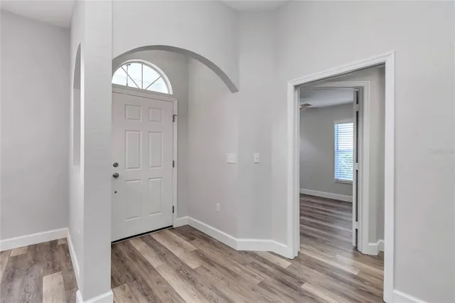 a view of a hallway with wooden floor and a livingroom