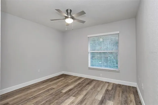 a view of an empty room with wooden floor