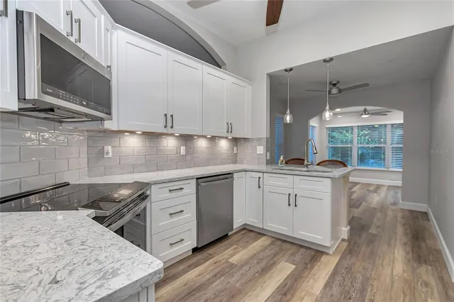 a kitchen with white cabinets and stainless steel appliances