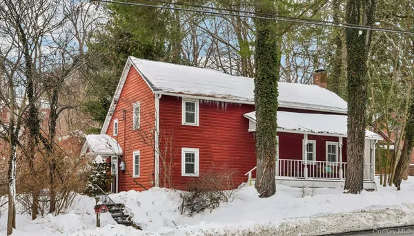 a view of a house with a yard and large tree