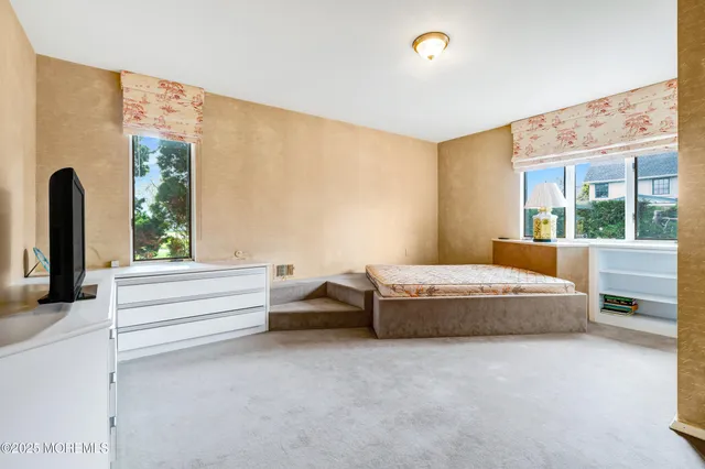 a spacious bedroom with a large bed and windows