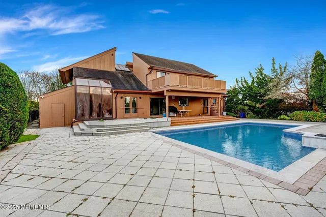 a view of a house with pool and sitting area