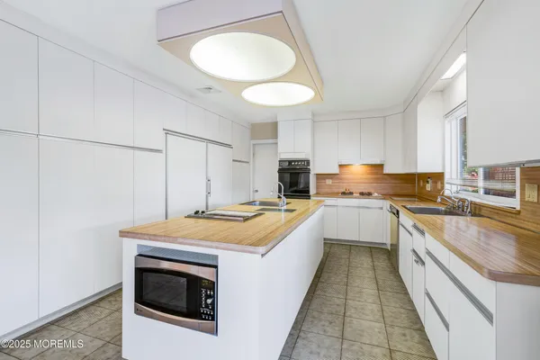 a kitchen with a stove sink and cabinets