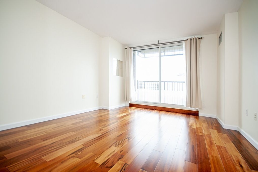 10 Museum Way, Unit 1521 Cambridge, MA 02141 - Photo 11 of 21 a view of an empty room with wooden floor and a window