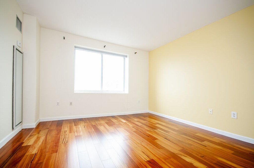 10 Museum Way, Unit 1521 Cambridge, MA 02141 - Photo 14 of 21 a view of an empty room with wooden floor and a window