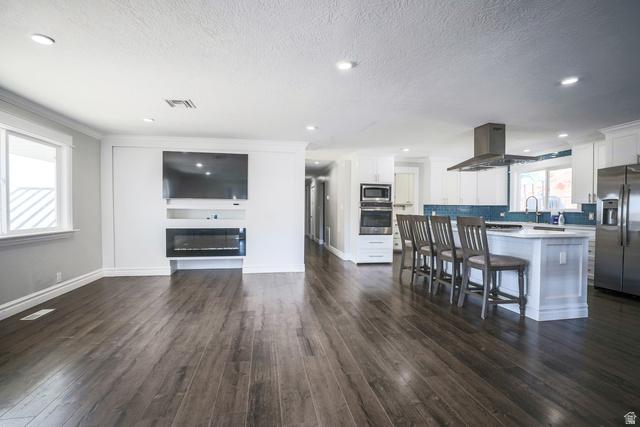 422 West Buckeye Reef Road Leeds, UT 84746 - Photo 4 of 47 Kitchen featuring stainless steel appliances, white cabinets, a breakfast bar area, a kitchen island, and dark wood-style flooring
