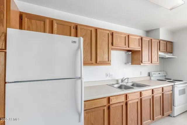 a kitchen with stainless steel appliances granite countertop a refrigerator sink and cabinets