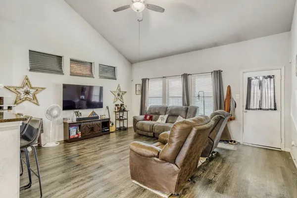 a living room with furniture a flat screen tv and a fireplace