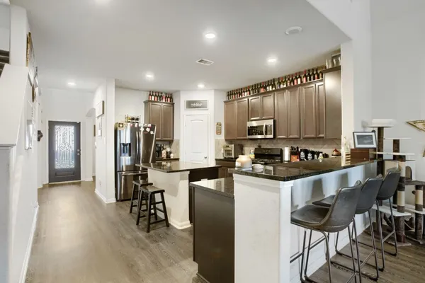 a kitchen with stainless steel appliances kitchen island granite countertop a refrigerator and cabinets