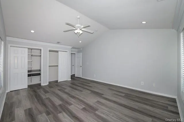 a view of empty room with wooden floor and ceiling fan