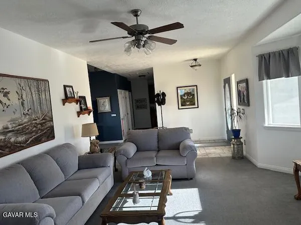 a living room with furniture and a ceiling fan