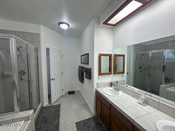 a spacious bathroom with a double vanity sink and mirror