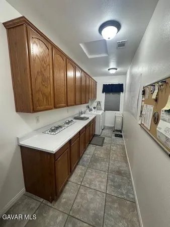 a large kitchen with a stove a refrigerator and wooden floor