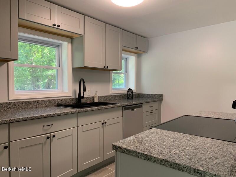 2312 State Road Richmond, MA 01254 - Photo 21 of 37 a kitchen with granite countertop white cabinets sink and window