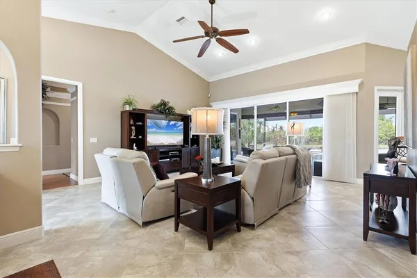 a living room with furniture a ceiling fan a fireplace and a large window