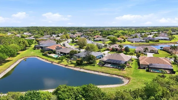 an aerial view of residential houses with outdoor space and trees