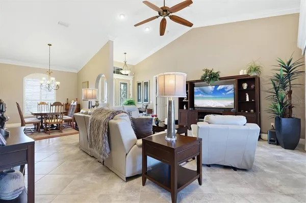 a living room with furniture a chandelier and a flat screen tv