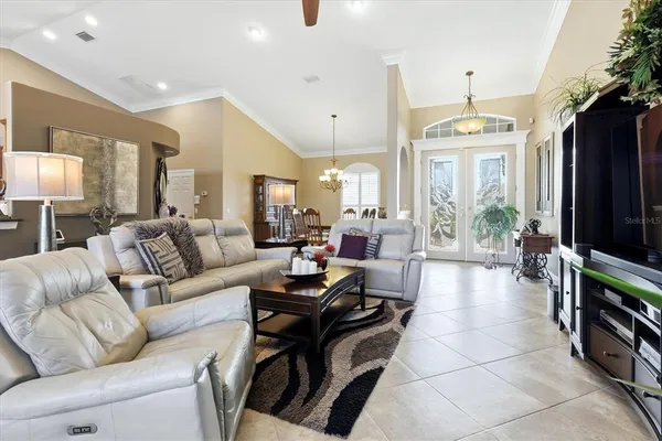 a living room with furniture a flat screen tv and a large window