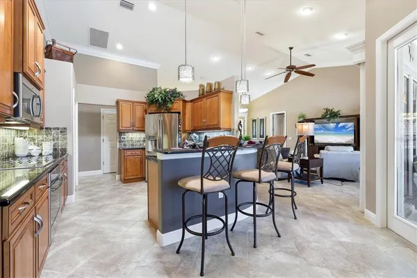 a kitchen with stainless steel appliances kitchen island granite countertop a refrigerator and microwave